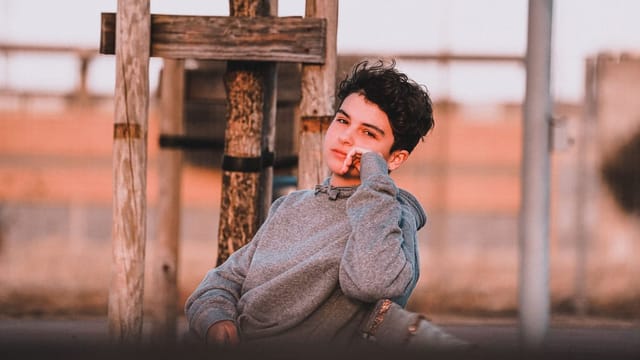 Thoughtful teenager with a hand near their face