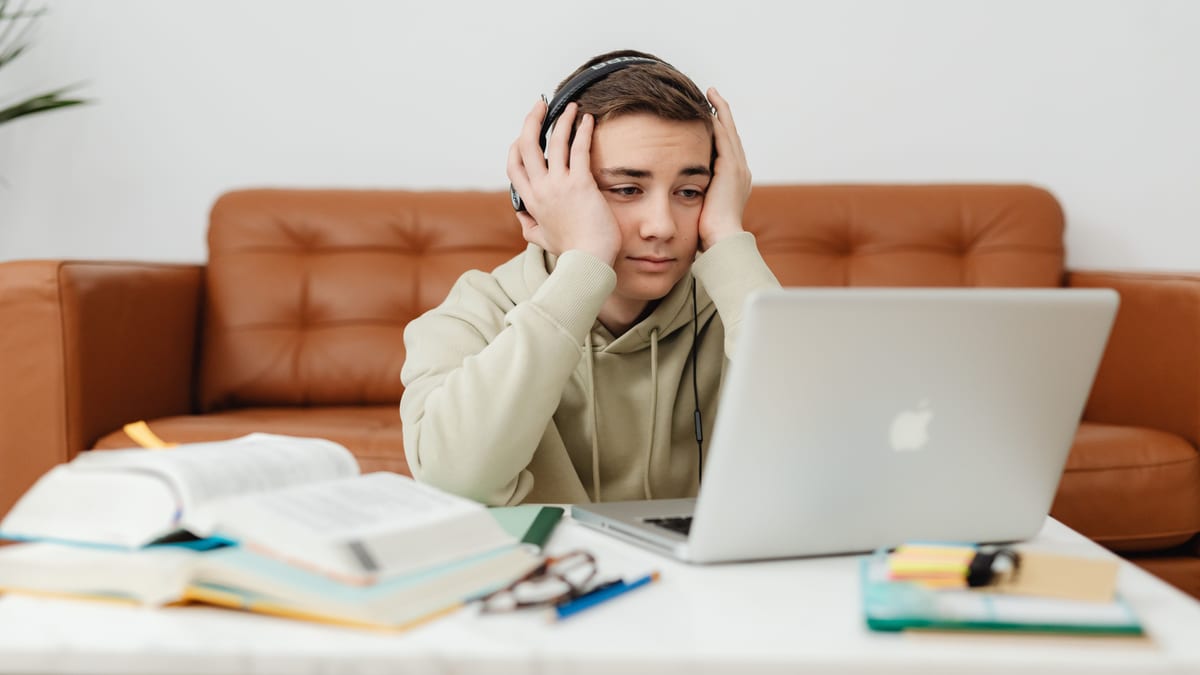 Overwhelmed teenager in front of a laptop during an online class