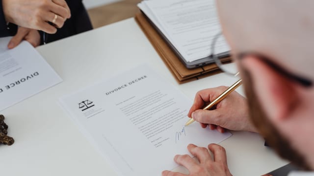 Signing a legal deed at an office