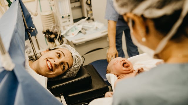 Midwife with a newborn at the maternity ward