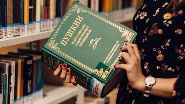 Person holding a book in a foreign language