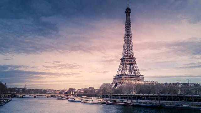 The Eiffel Tower at sunset, seen from the banks of the Seine