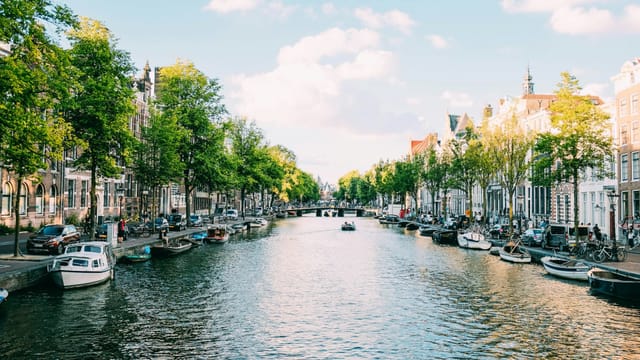 Canal lined with narrow houses and boats in central Amsterdam